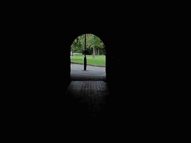 Photo of dark tunnel with lamp at end of it