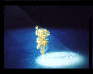 A plastic figure spinning on ice with a spotlight on it