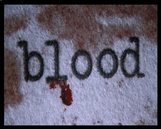 The word "Blood" typed out on paper with blood oozing from the words.