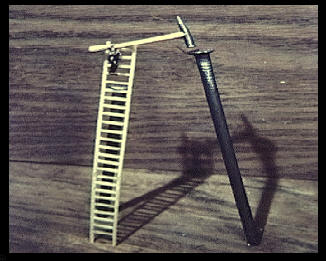 Nail with a tiny ladder and model of a man with tiny hammer